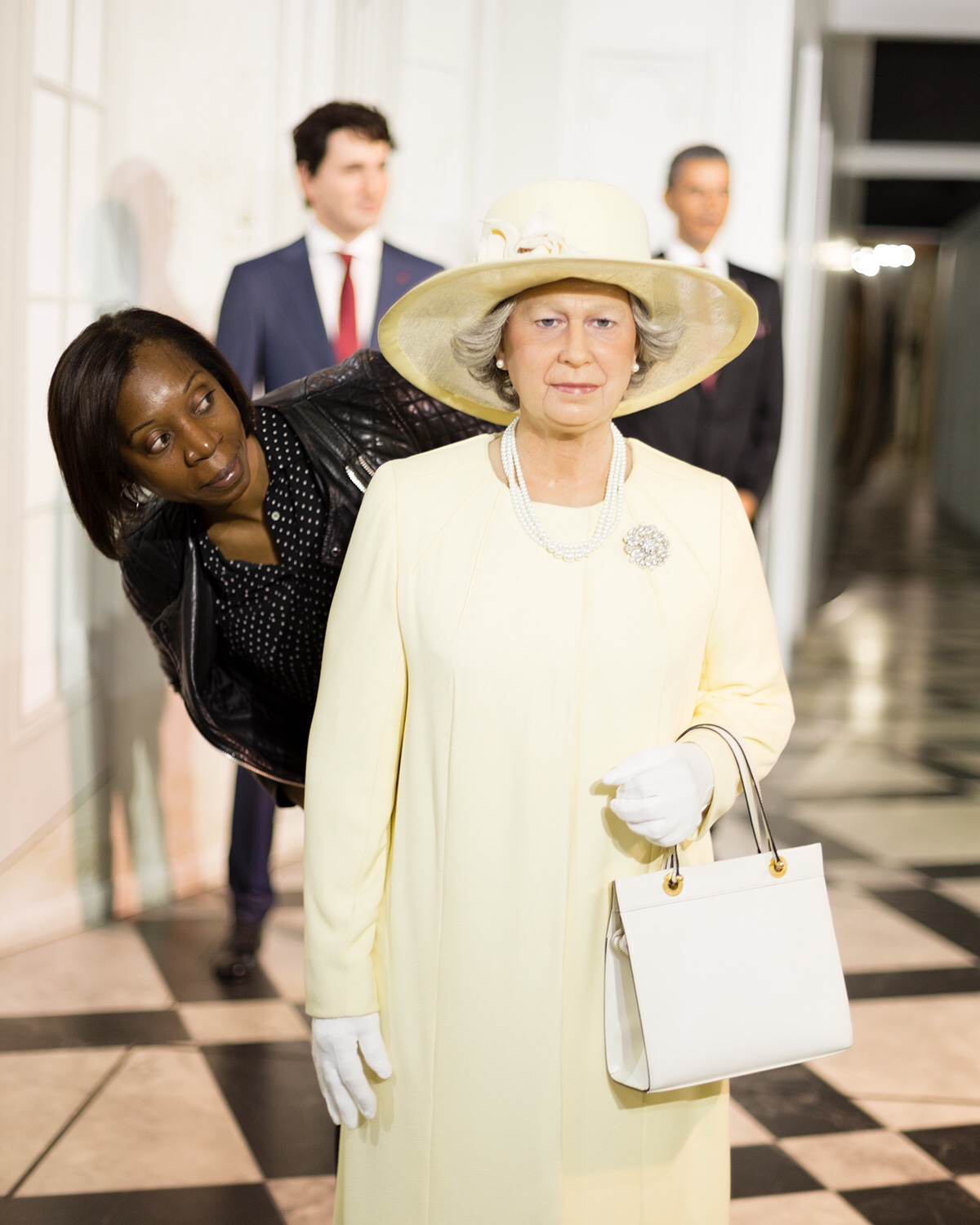 Woman standing beside wax statue of Queen Elizabeth in wax museum