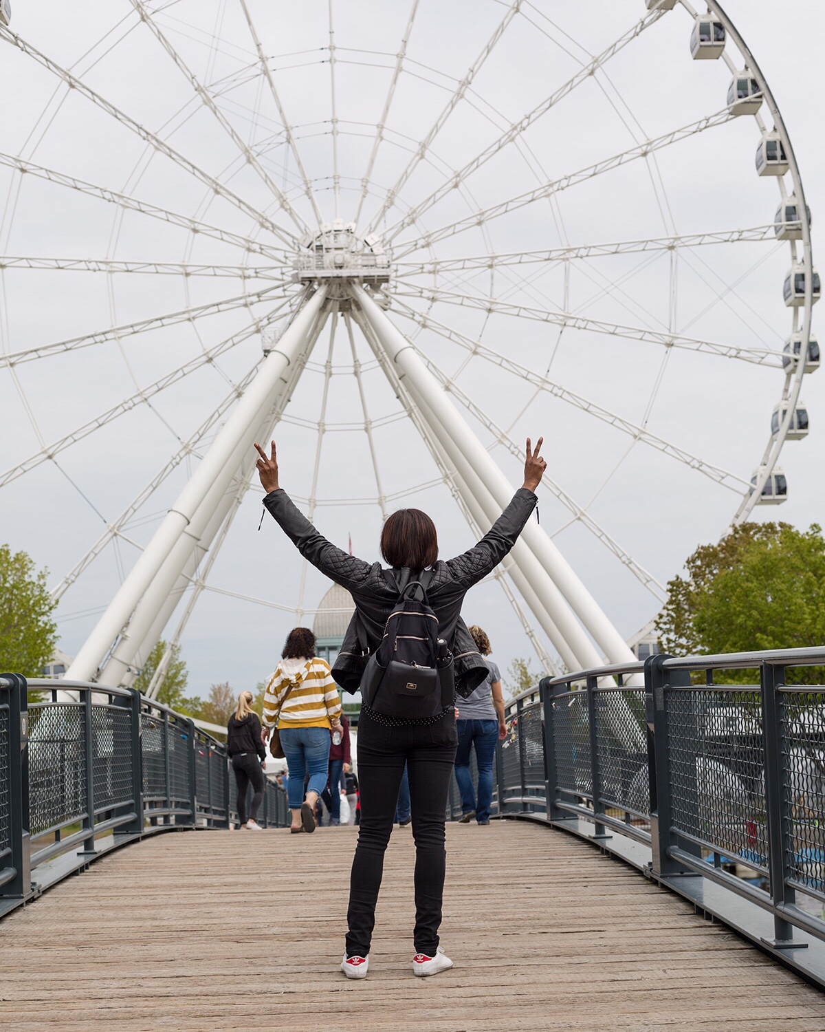 Woman standing in front of a giant Ferris Wheel in Old Port Montreal