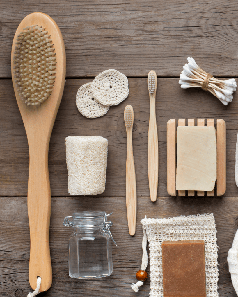 recyclable wood and bamboo bath products (a back scrubber, loofah sponge, bamboo toothbrushes, natural soaps and glass jars 